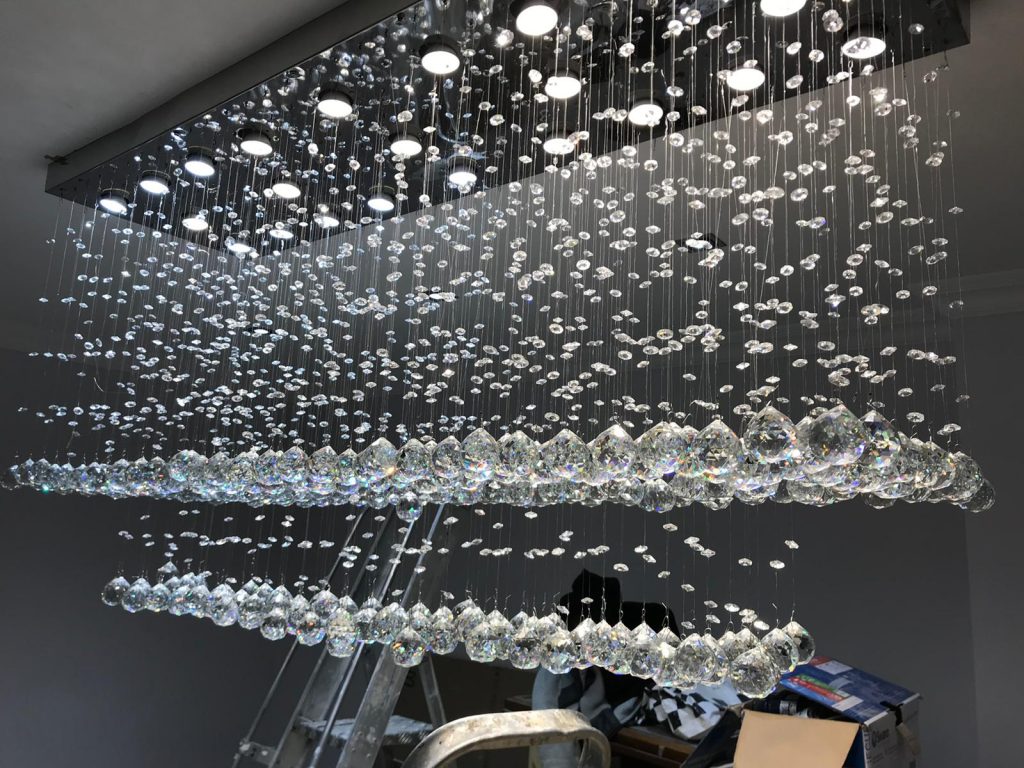 an electrician installing a chandelier